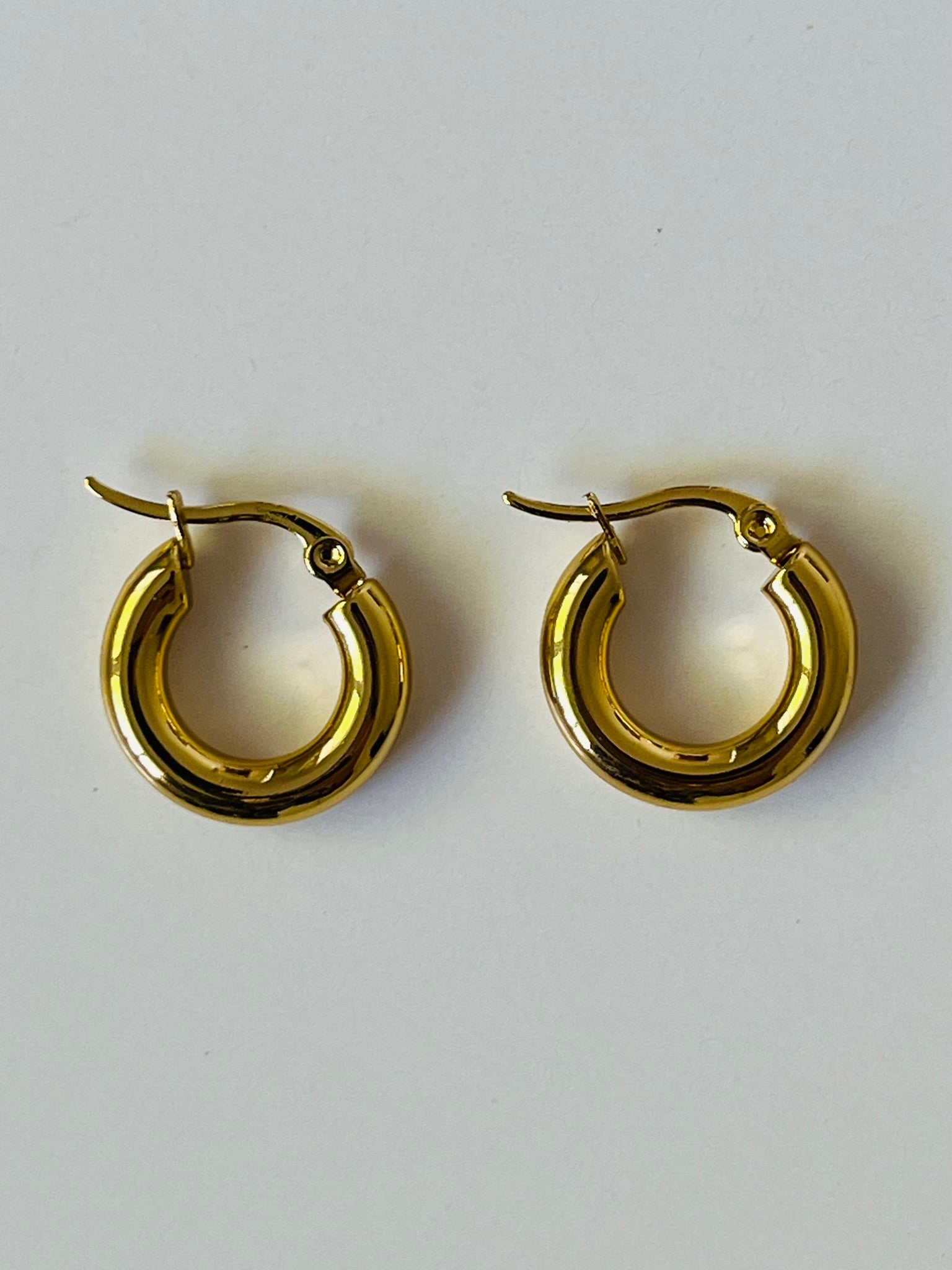 Gold chunky mini gold hoop earrings with a clasp. Waterproof, tarnish proof and hypoallergenic.