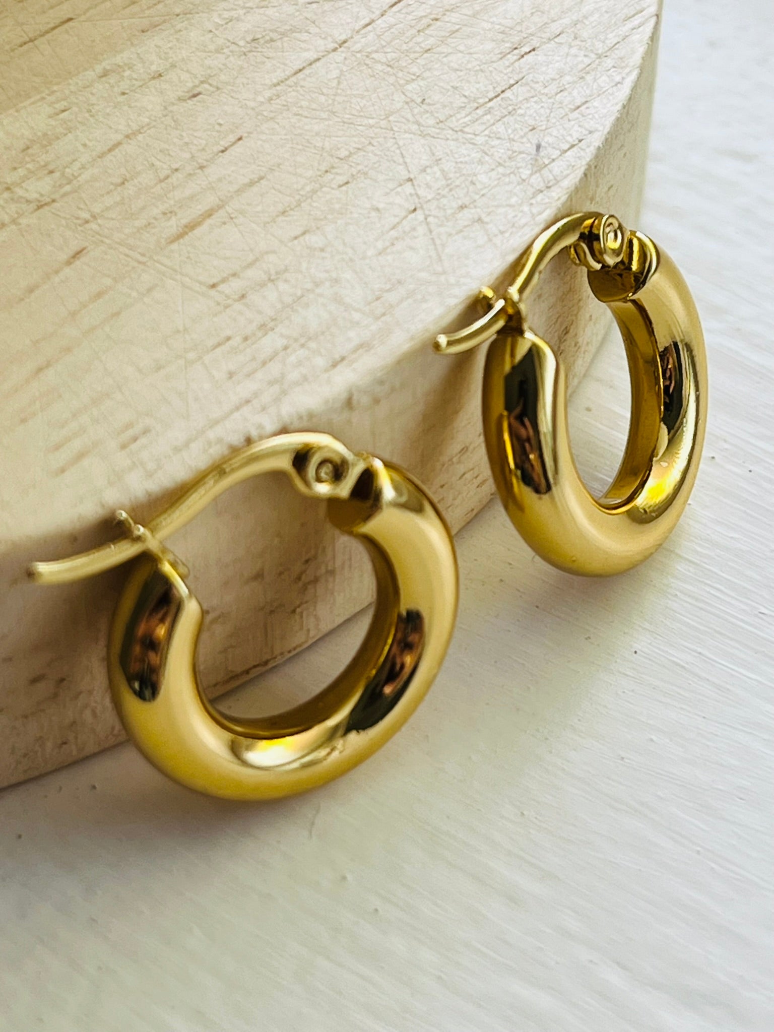 Gold chunky mini gold hoop earrings with a clasp. Waterproof, tarnish proof and hypoallergenic.