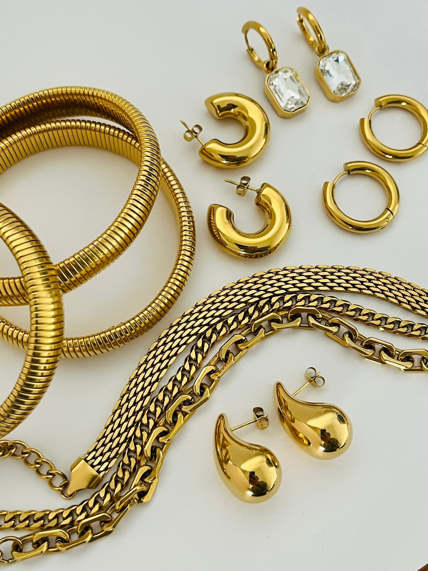 A selection of gold, chunky jewellery pieces including earrings, bracelets and stretch bangles. 
